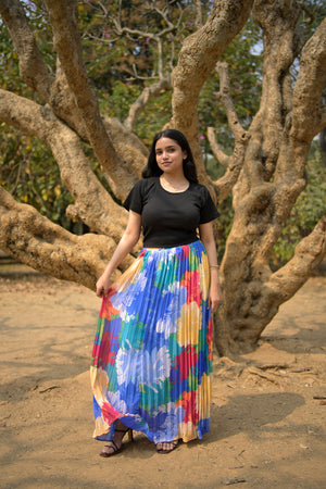 Woman holding a colorful skirt in front of a tree trendybuzz
