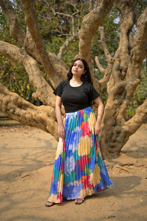 Woman in a colorful dress standing among tree branches trendybuzz