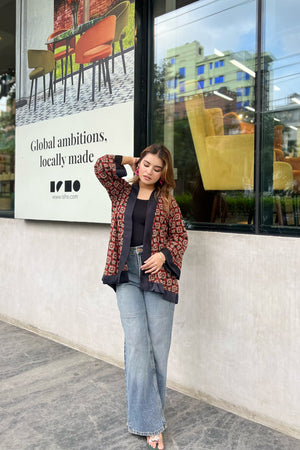 Woman wearing Short Kimonos posing in front of a store window with a visible brand advertisement.