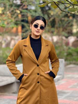 Woman wearing a brown coat and sunglasses outdoors