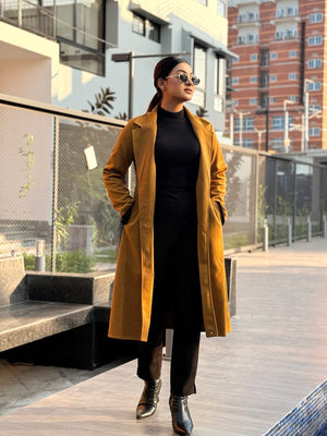 Person wearing a yellow coat and black outfit in an urban setting