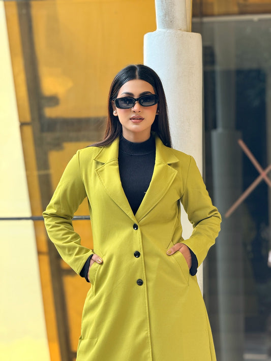 Woman wearing a bright yellow coat and sunglasses in an urban setting