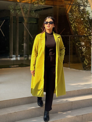 Woman in a yellow coat standing on steps outside a modern building