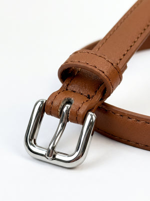 A close-up of a brown leather belt with a polished silver-tone metal buckle, shown on a clean white background.