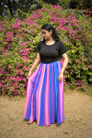 Person holding a colorful striped skirt with flowers and grass in the background