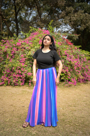 Woman in a colorful dress standing in a park with flowers and trees. trendy buzz