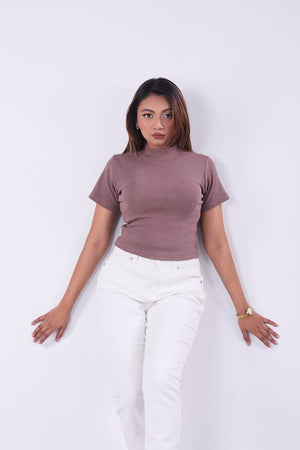 Woman wearing a mauve t-shirt and white pants on a white background