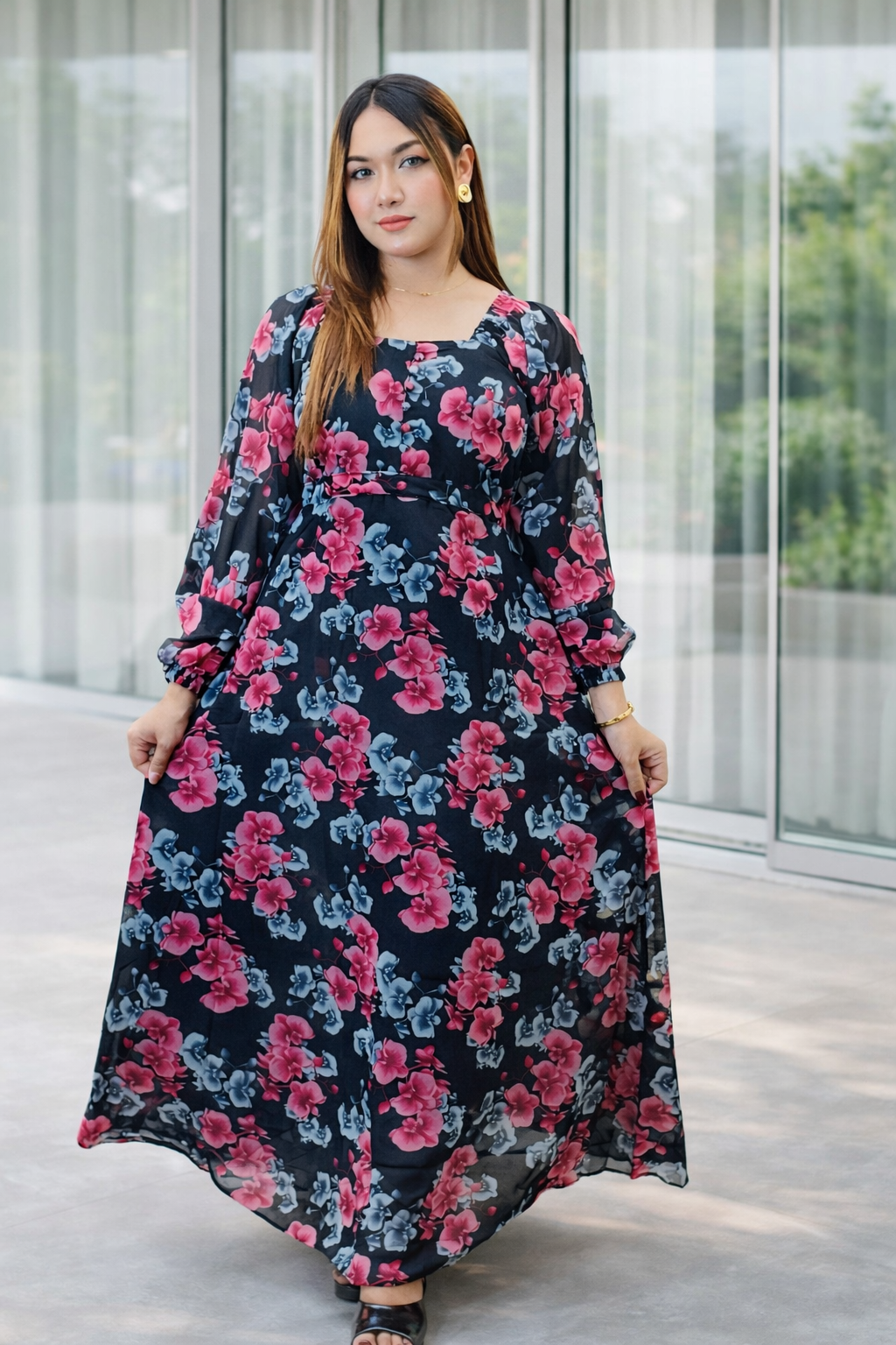 Woman wearing a floral dress standing outdoors with a blurred background