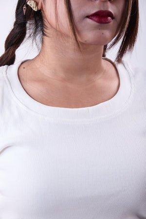 Close-up of a person wearing a white top with a blurred background