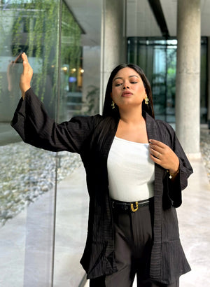 Woman wearing a premium solid black crinkle crepe kimono with textured popcorn fabric