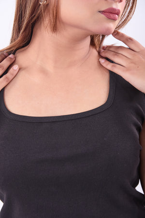 Woman wearing a black top with a close-up of her neck and shoulders.