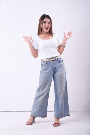 Woman wearing a white t-shirt and blue jeans on a white background