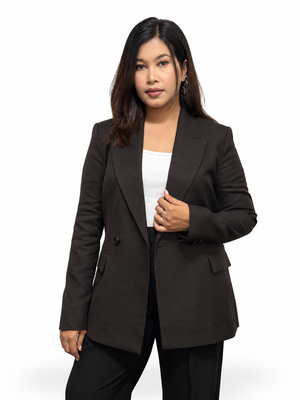 A woman modeling a dark brown double-breasted blazer over a white top and black pants, photographed against a clean white studio background.