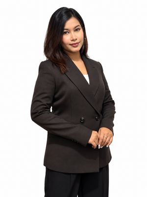 A woman modeling a dark brown double-breasted blazer with notched lapels, paired with black trousers and a white top, against a solid white background.