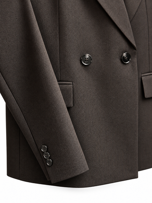 Close-up of a dark brown double-breasted suit jacket, showing the lapels, double-breasted buttons, and pocket flaps on a clean white background.