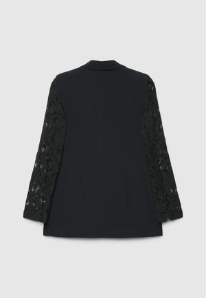 A black long-sleeve blazer shown from the back, featuring solid black fabric on the back panel and intricate black lace detailing on the sleeves, set against a light gray background.