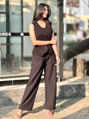 Woman wearing a brown outfit standing outdoors with blurred background