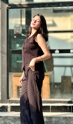 Woman in a brown outfit standing outdoors with a blurred background