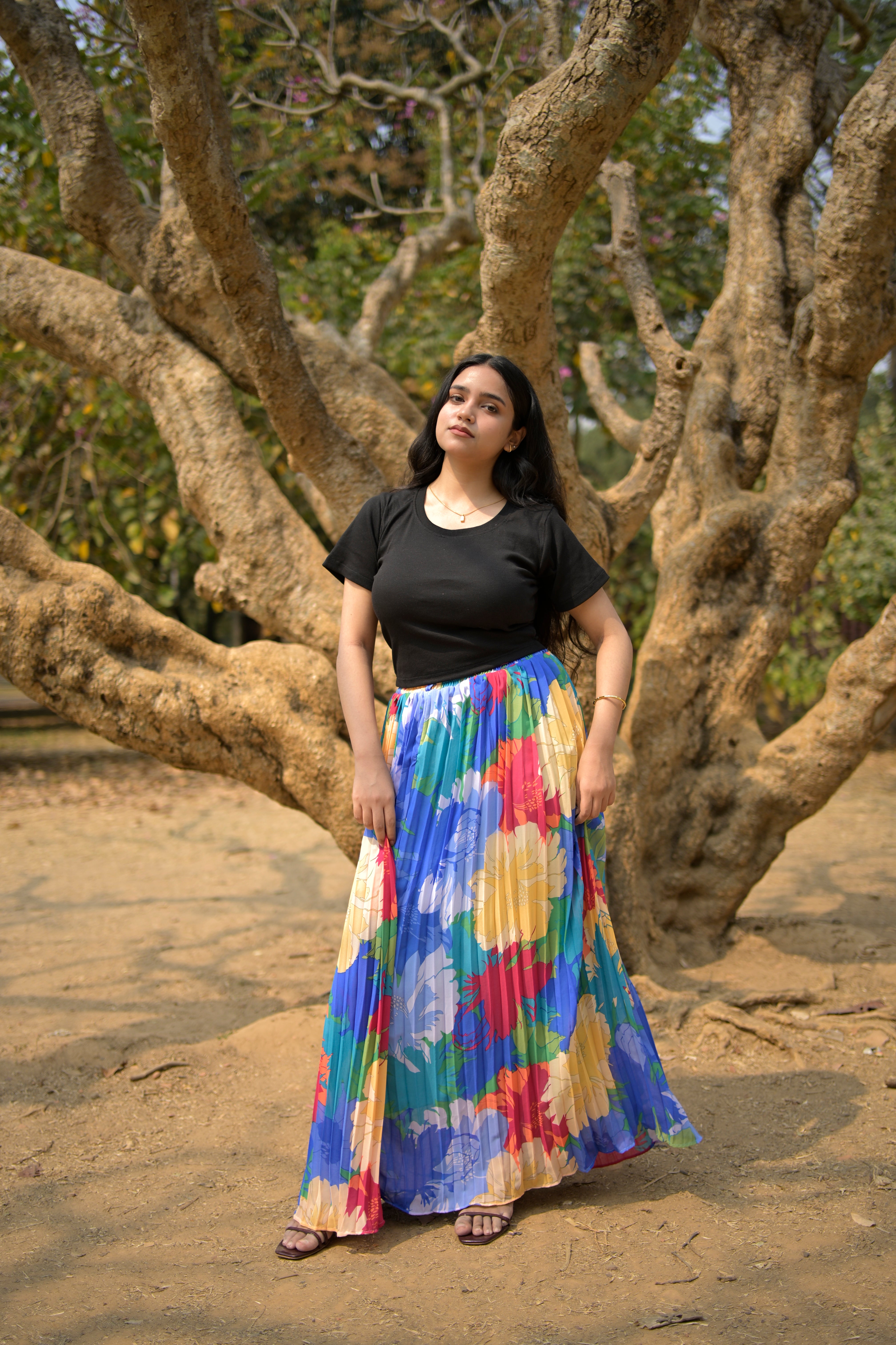 Woman in a colorful dress standing among tree branches trendybuzz