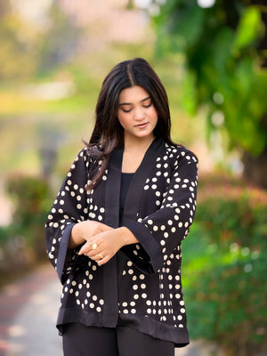 Woman wearing a black blazer with white polka dots outdoors