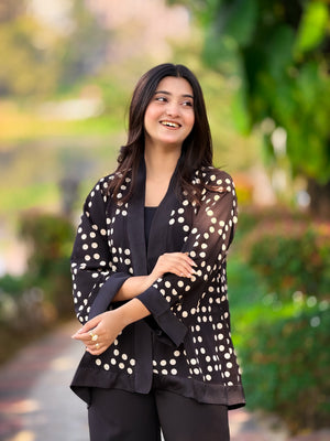 Woman wearing a black outfit with white polka dots in an outdoor setting