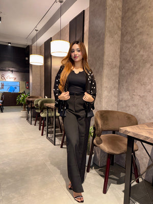 Woman in a black Polka dot Kimono Outfit standing in a modern cafe interior.