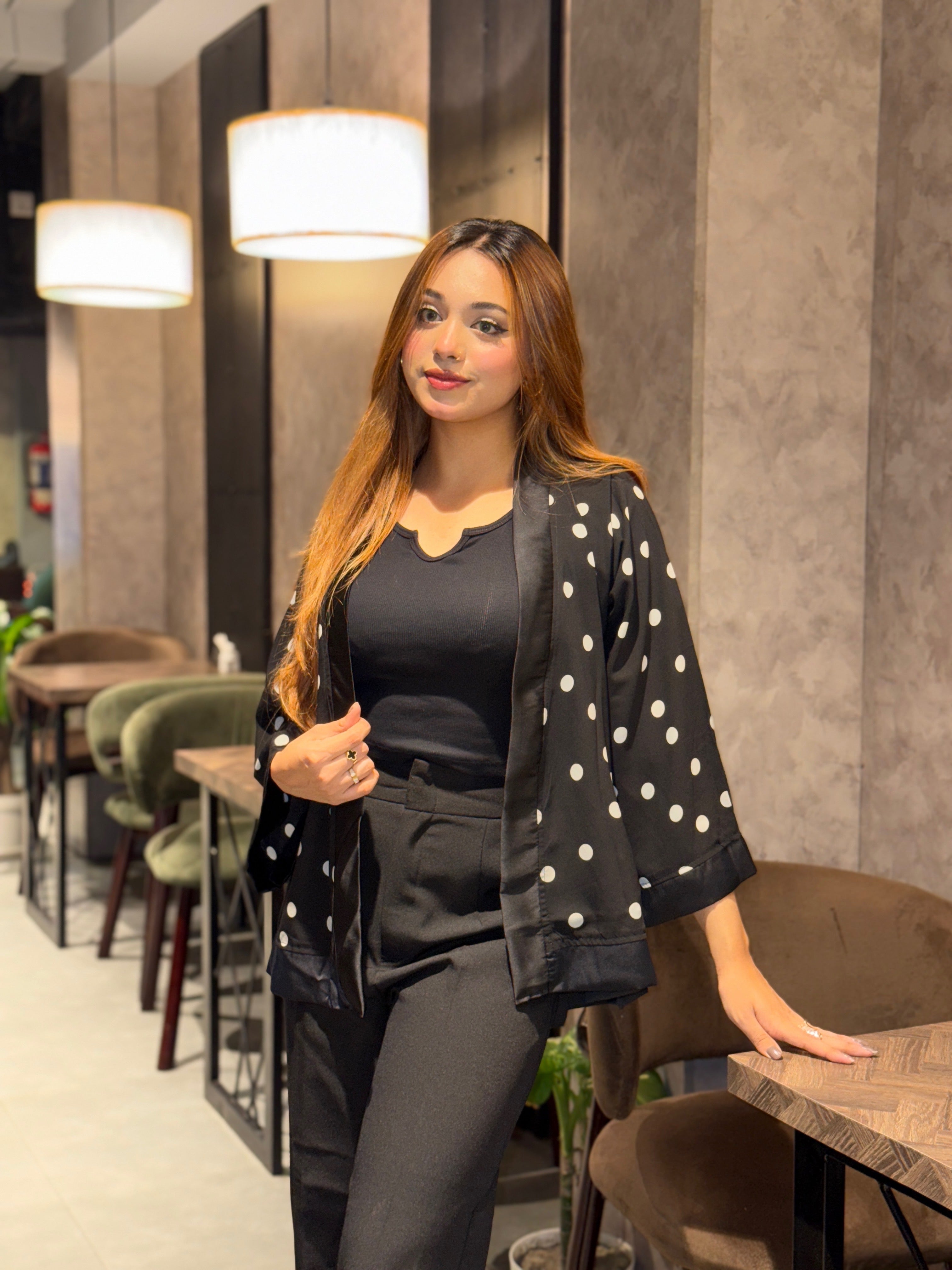 Woman in a polka dot Kimono standing in a modern cafe.