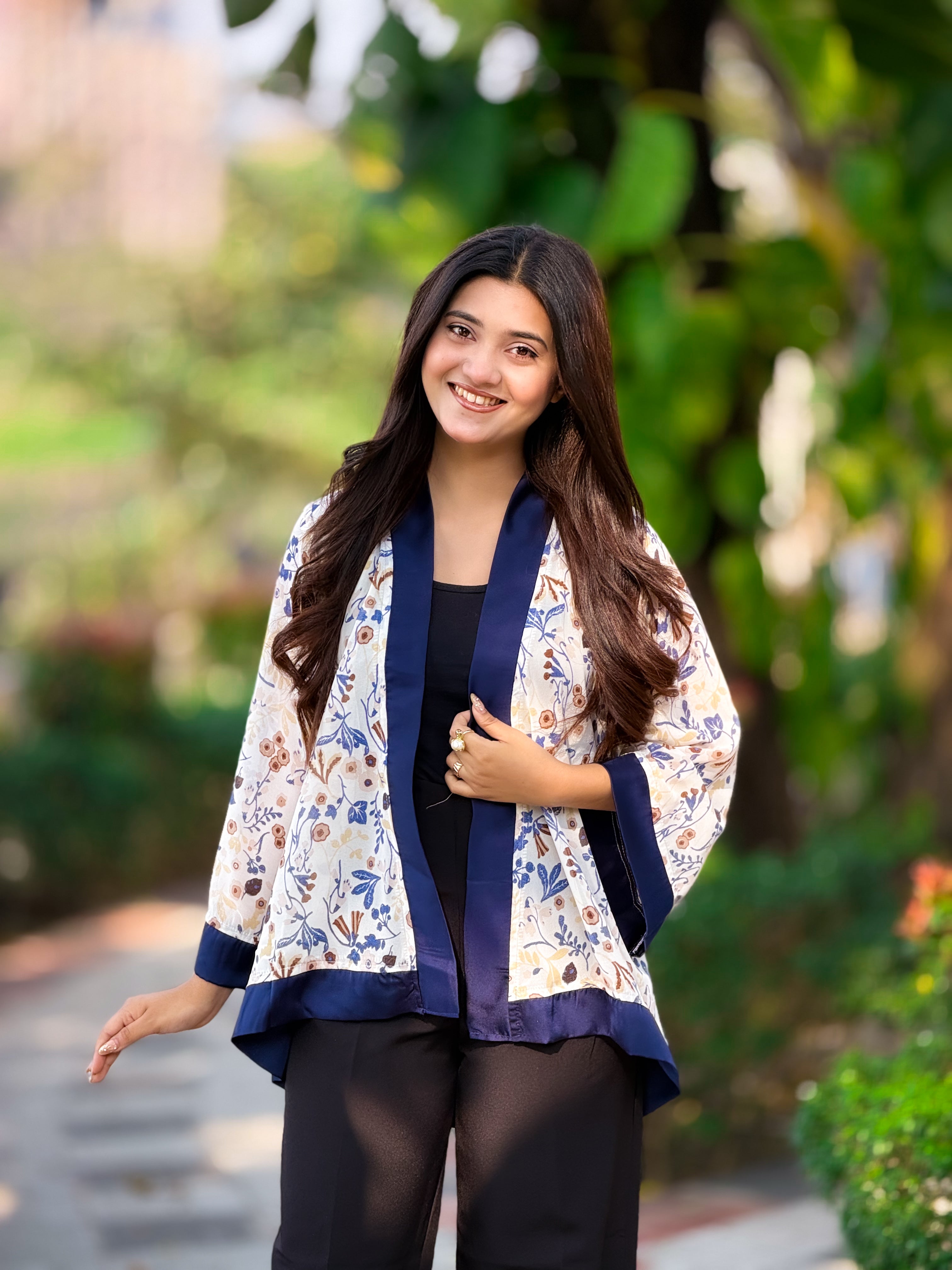 Woman wearing a floral jacket with a blurred green background
