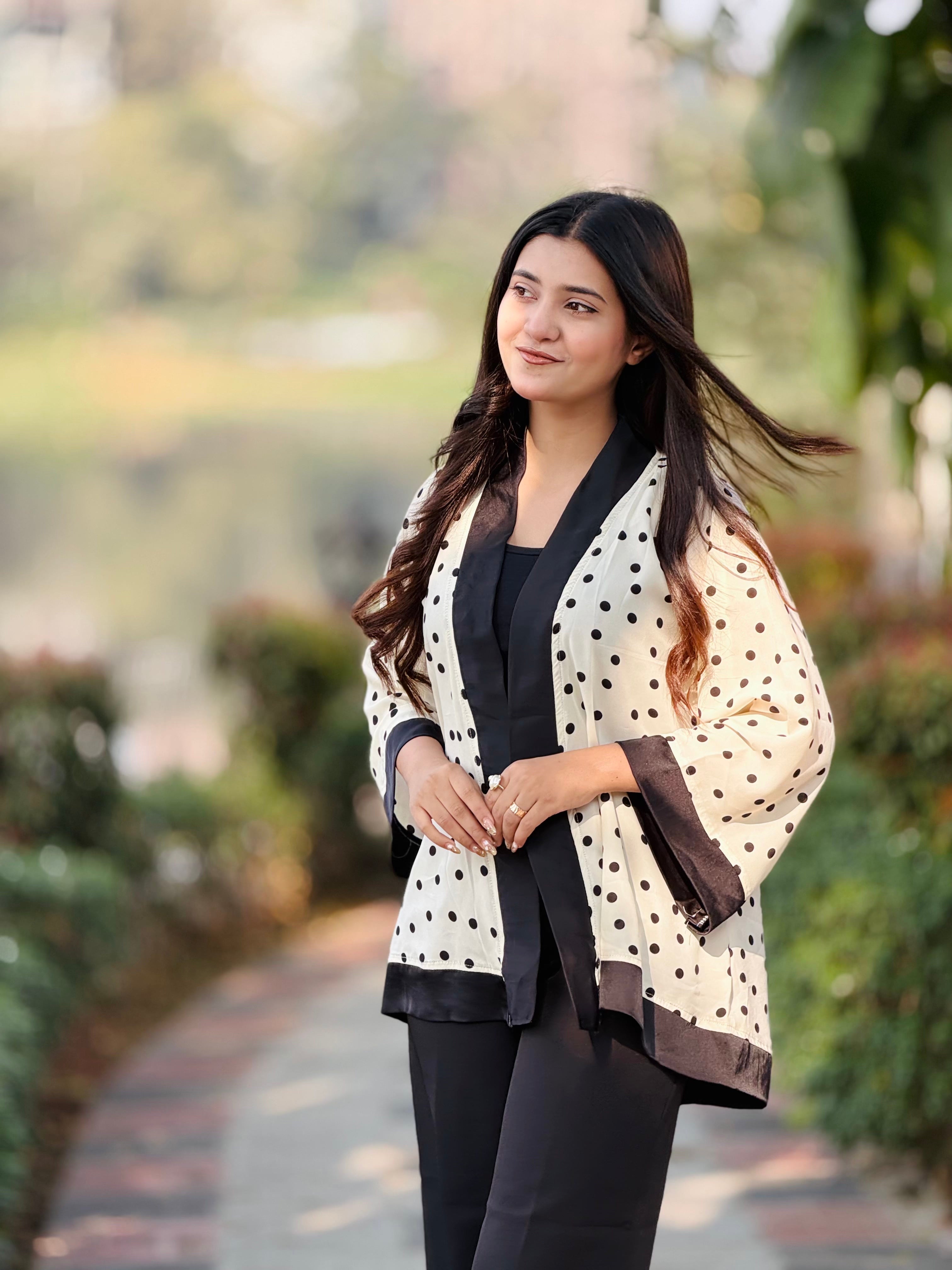 Woman wearing a polka dot scarf outdoors with greenery in the background