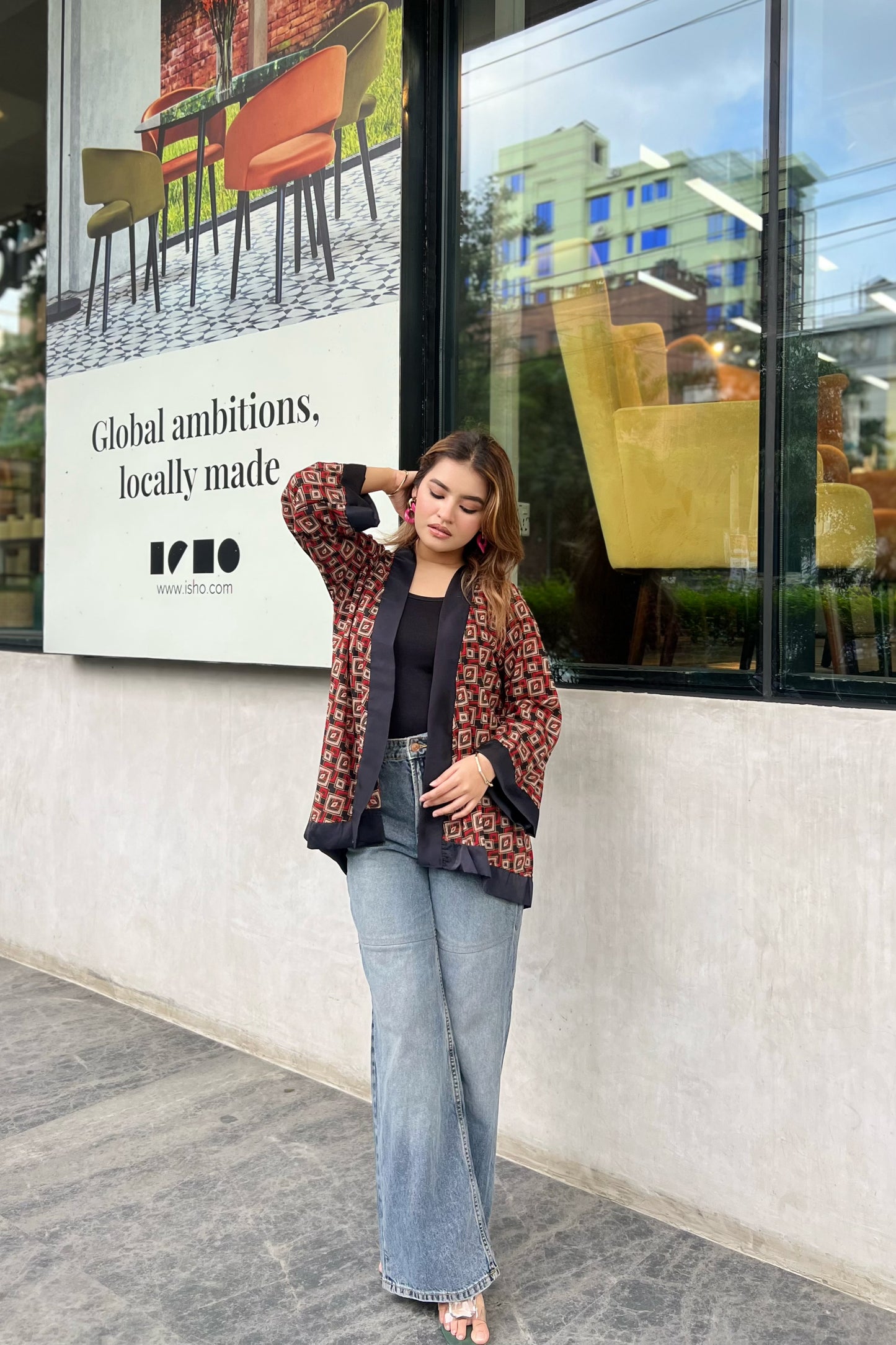 Woman wearing Short Kimonos posing in front of a store window with a visible brand advertisement.