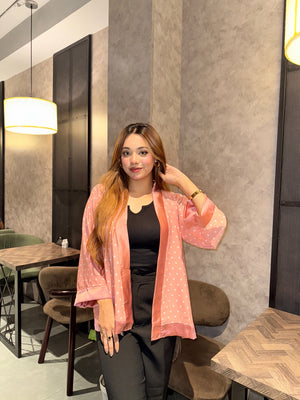 Woman in a Misty polka dot Kimono over a black top standing in a modern interior setting.