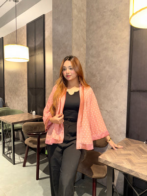 Woman sitting at a table in a modern restaurant setting wearing our Misty polka dot Kimono over a black top