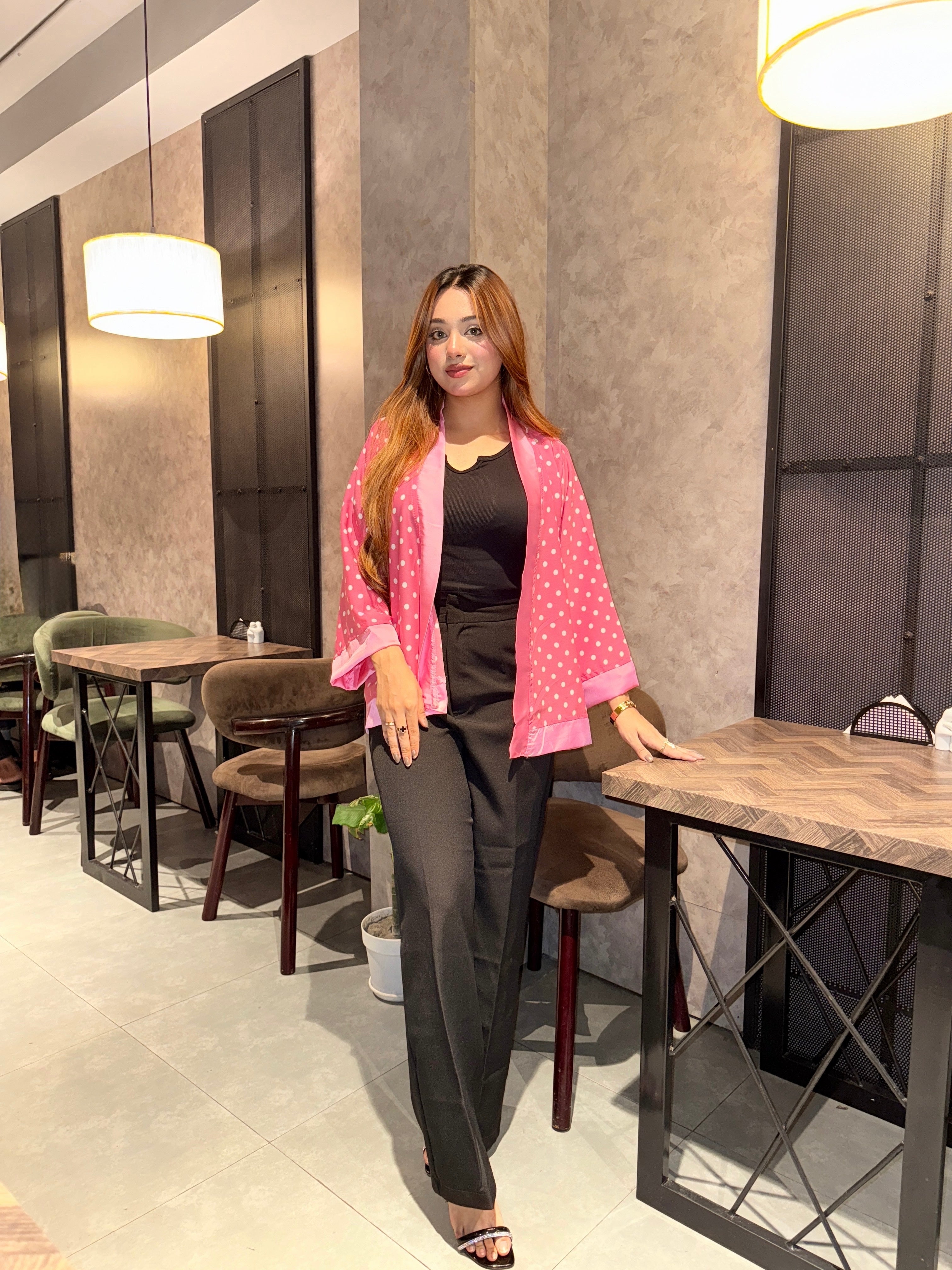 Woman in a pink polka dot kimono standing in a modern restaurant setting