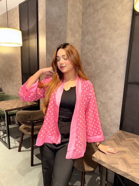 Woman wearing a pink polka dot kimono in an indoor setting