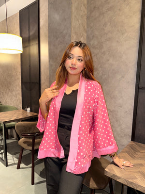Woman wearing a pink polka dot kimono in an indoor setting