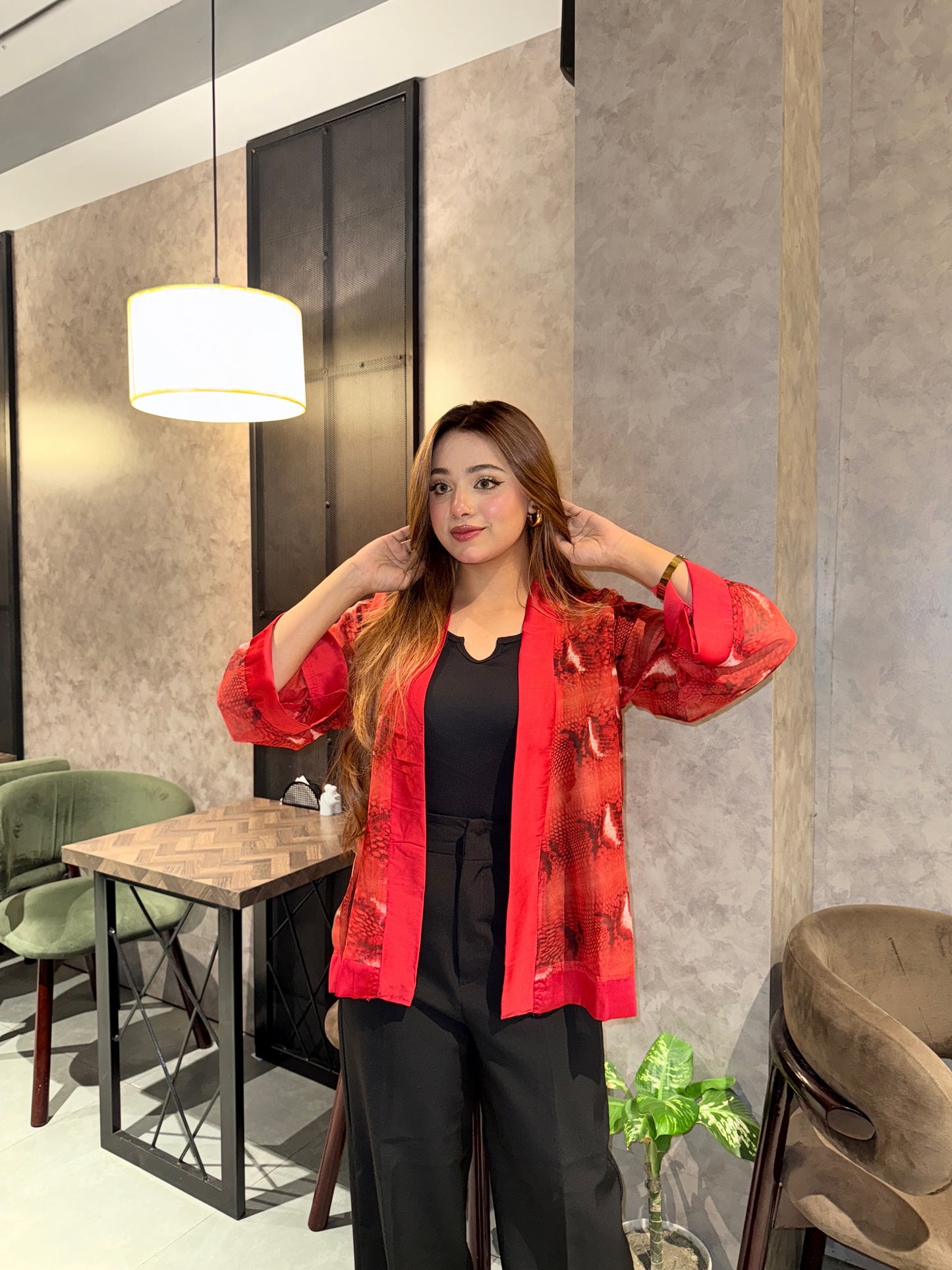 Woman wearing a red snake print kimono in a modern interior setting