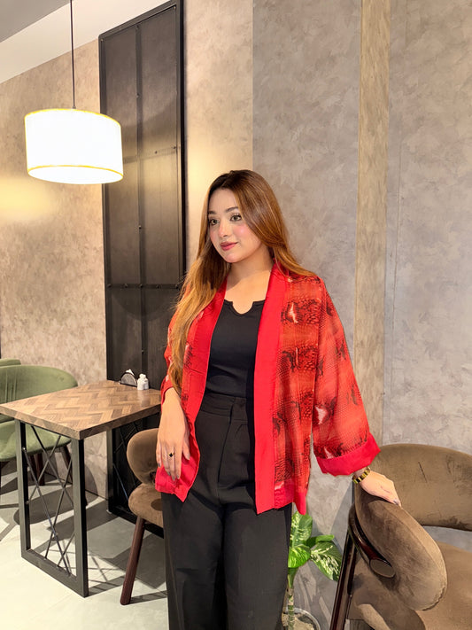 Woman wearing a red snake print kimono in an indoor setting