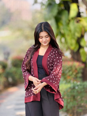 Woman wearing a maroon polka dot kimono-style jacket outdoors