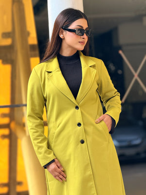 Woman wearing a bright yellow coat and sunglasses in an urban setting