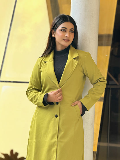 Woman wearing a green trench coat against a yellow and black background