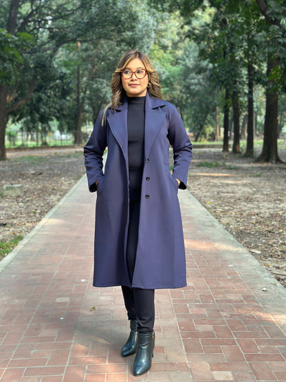 Person wearing a long purple coat in a park setting