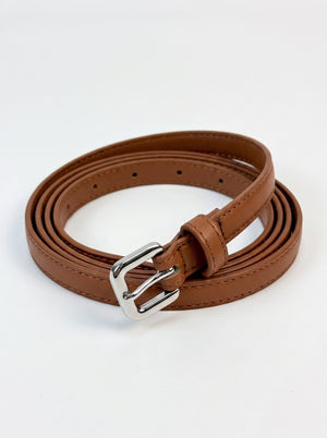 A brown faux leather belt with a silver-tone metal buckle, neatly coiled on a white background.