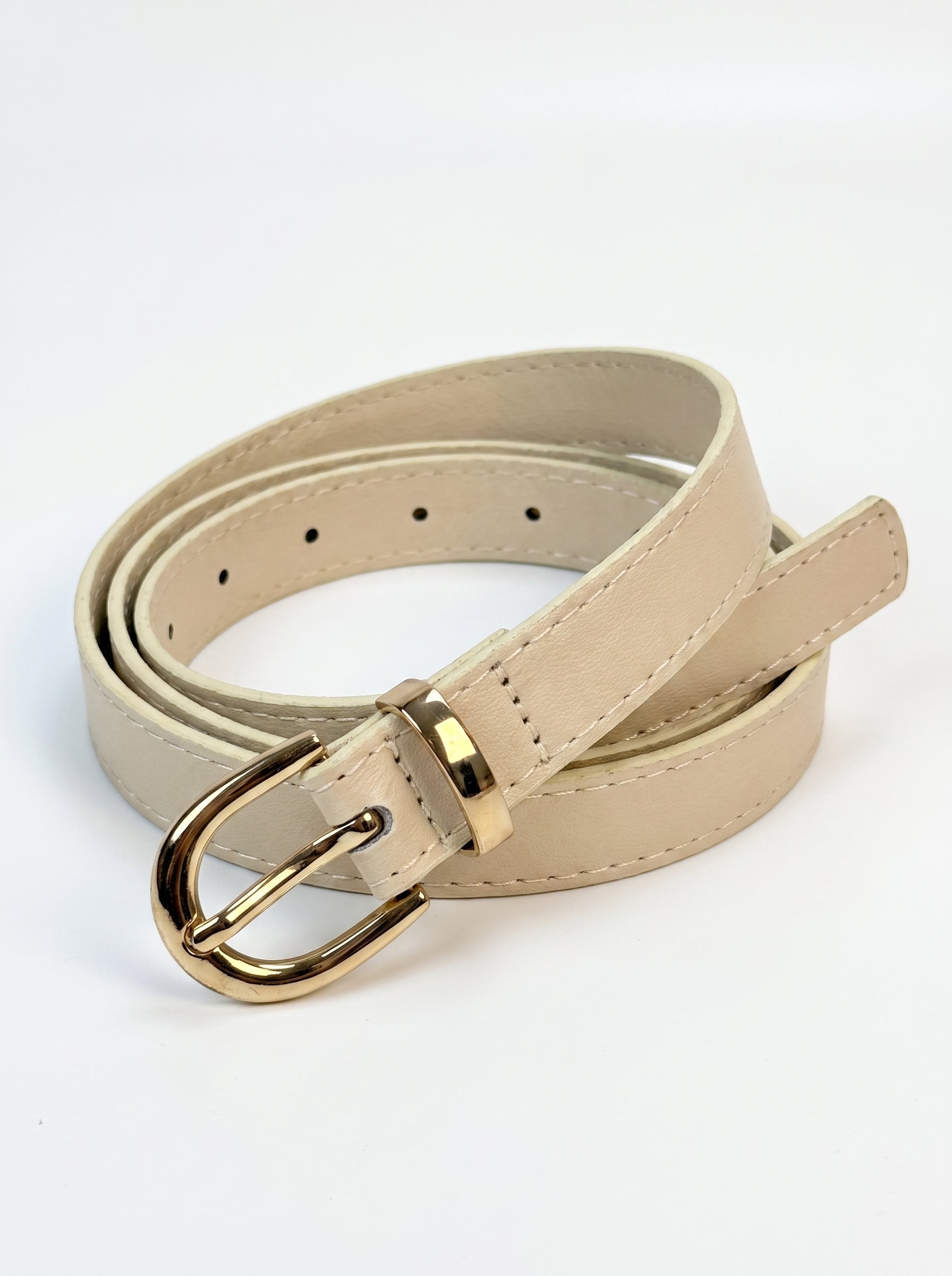 A light beige faux leather belt with a polished gold-tone metal buckle, neatly coiled on a white background.