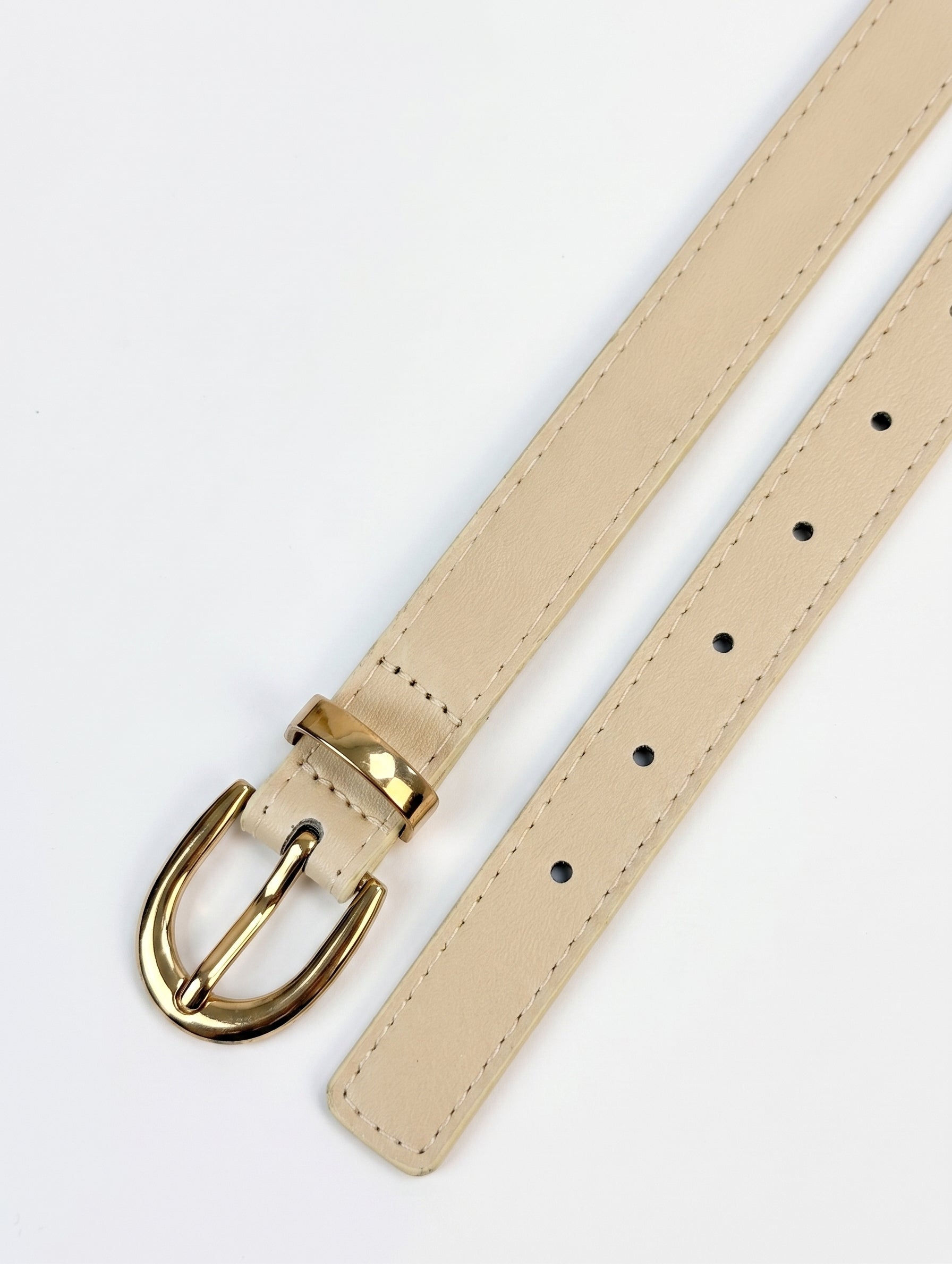 A light beige leather watch strap with a polished gold-tone metal buckle, shown on a clean white background.