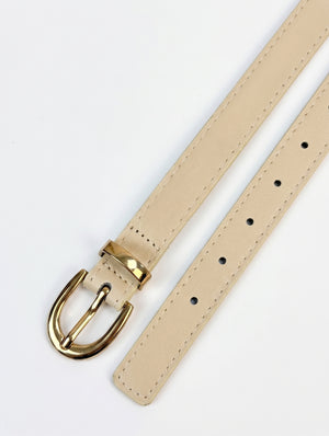 A light beige leather watch strap with a polished gold-tone metal buckle, shown on a clean white background.