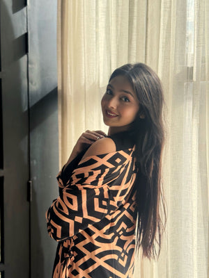 Woman wearing a long shrug outerwear  in black and orange .