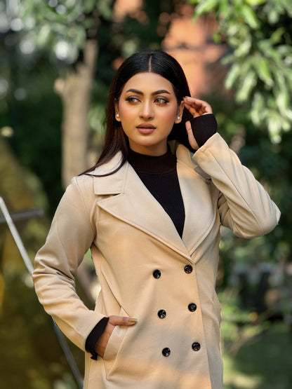 Woman wearing a beige trench coat with black buttons outdoors