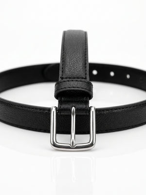 A black textured leather belt with a silver-tone metal buckle, shown coiled on a clean white reflective surface.