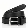 A black pebbled leather belt with a silver-tone metal buckle, neatly coiled on a reflective white surface.