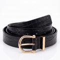 A black crocodile-embossed leather belt with a polished gold-tone metal buckle, coiled on a reflective white surface.